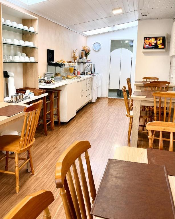 Salão do café da manhã da Pousada Bello Outono, com buffet e mesas de madeira
