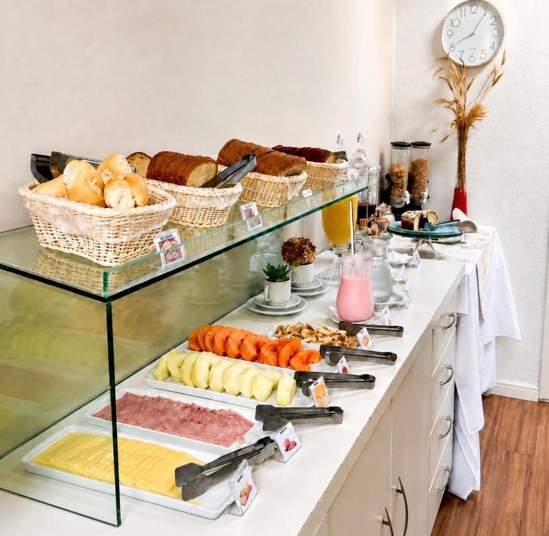 Buffet do café da manhã, com pães, frios, frutas e sucos